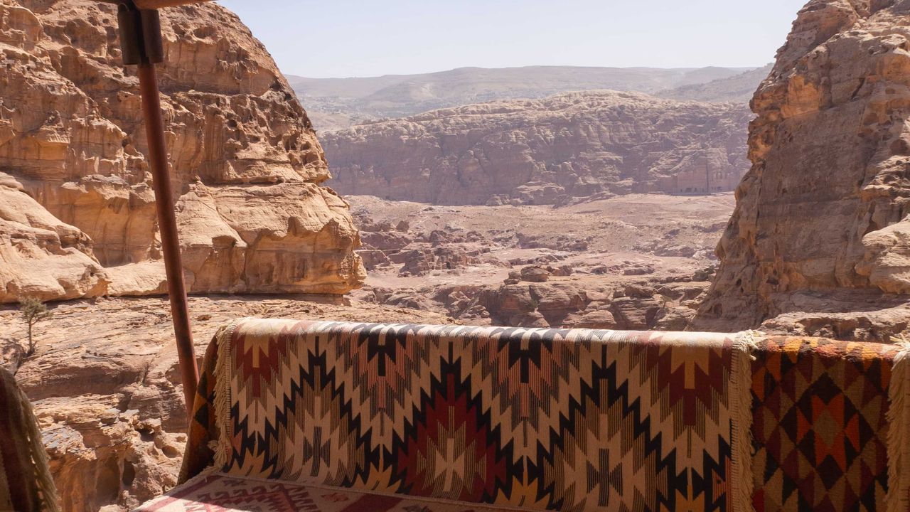 Bench with a jordanian red blanket with a view on the Petra valley