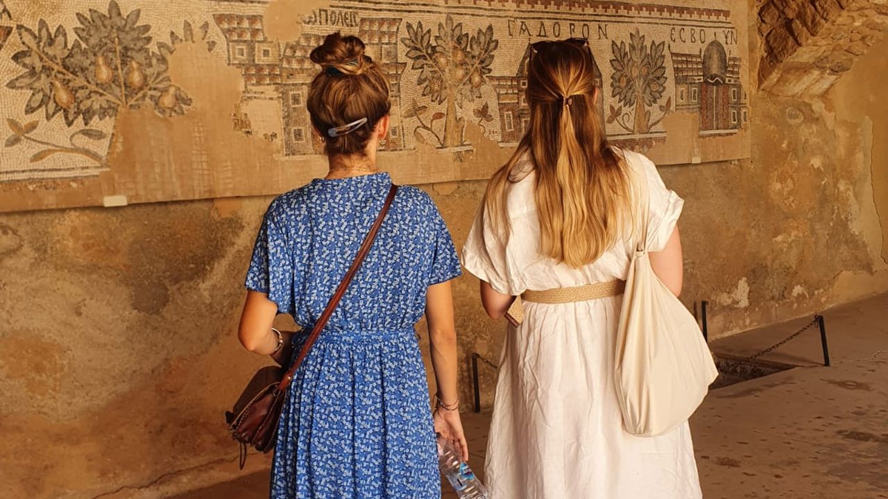 Two persons watching the Byzantine mosaics at the archeological park