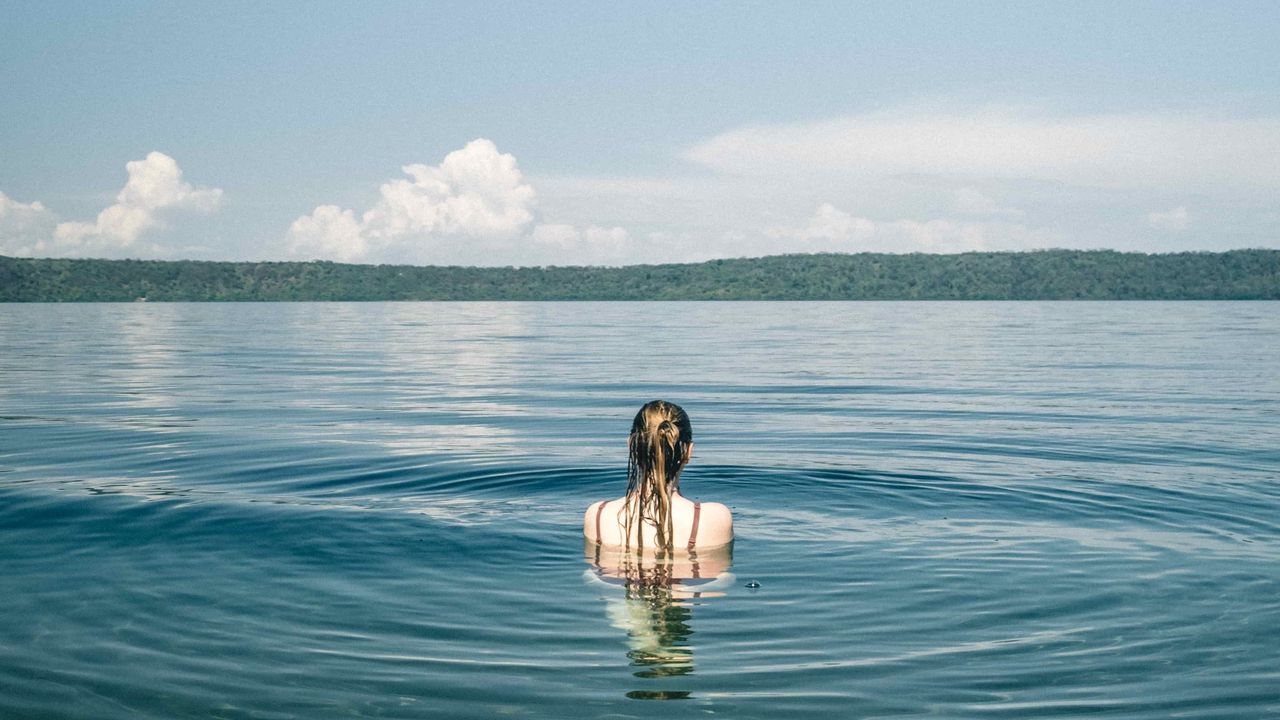 Someone swimming in a blue lake