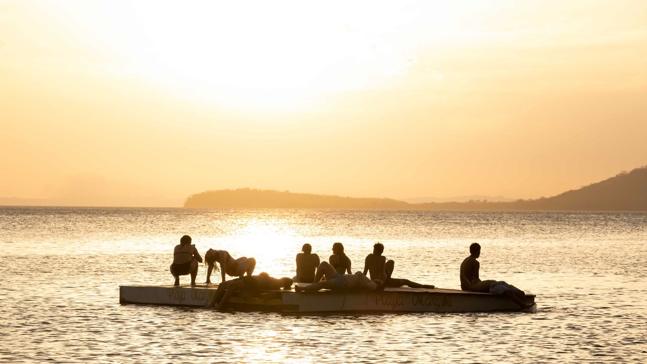 Platform in a lake, with people enjoying the sunset