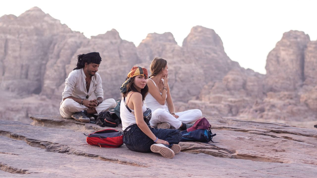 3 persons sitting on a rock in Petra